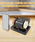 Grab And Go Cordless Mini Bench Grinder With Variable Speed Control Up To Seven Thousand RPM Dual Grinding Wheels Chew Through Metal Or Wood Like Butter Compact Job Site Essential on a wooden surface next to a smartphone for scale.