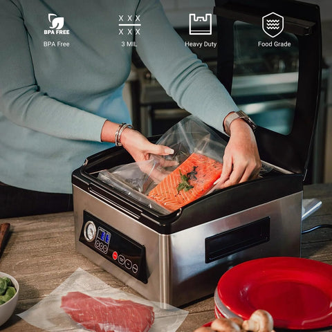 Front view of a stainless steel chamber vacuum sealer being used to seal a clear pre-cut bag with salmon.