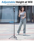 Woman standing next to Extendable Phone Tripod With 2 In 1 Phone Clip And 360 Degree Ball Head Aluminum Selfie Stick Stand Reaches Up To 82 Inches
