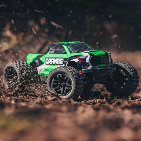 1/18 Scale Granite GROM Mega 380 Brushed 4x4 Monster Truck RTR in action on dirt, showing green body and rugged tires.