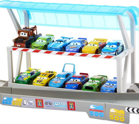 Toy cars lined up on the Ultimate Florida Speedway Track Set with Lightning McQueen Car and Motorized Booster, 5 feet long.
