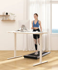 Woman using FLEXISPOT 40x24 Inch Electric Standing Desk White Ergonomic Height Adjustable Sit Stand Workstation walking on treadmill.