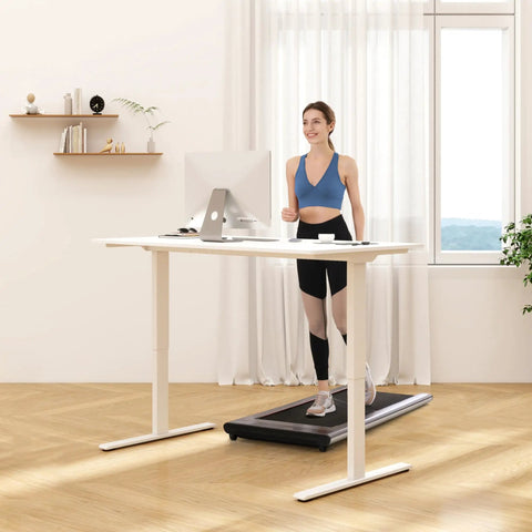 Woman using FLEXISPOT 40x24 Inch Electric Standing Desk White Ergonomic Height Adjustable Sit Stand Workstation walking on treadmill.