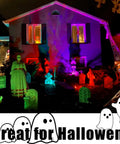 Color Changing Solar Spotlights Outdoor RGB Landscape Lighting illuminating a house and yard with Halloween decorations at night.