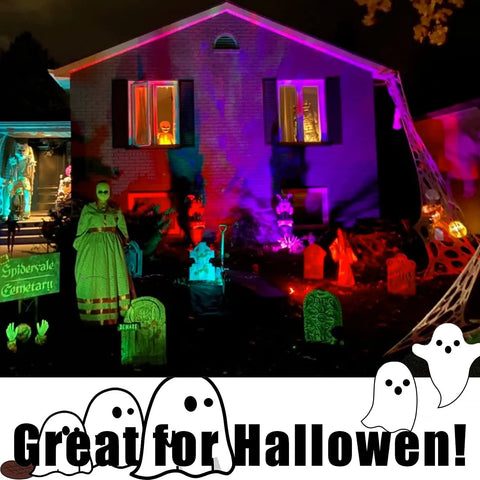Color Changing Solar Spotlights Outdoor RGB Landscape Lighting illuminating a house and yard with Halloween decorations at night.