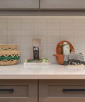 Countertop with baskets, books, clay pot, and cloth, featuring handles: Twenty Five Pack Solid Zinc Slim Square Bar Cabinet Pulls With Three And Three Quarters Inch Center To Center Matte Black Kitchen Drawer Handles Premium Quality Finish Sturdy Construction For Daily Kitchen Use.
