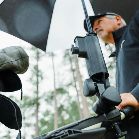 Man using Universal Umbrella Holder Clamp For Round Or Oval Tubing Fits Golf Carts Strollers Bikes And More with umbrella attached