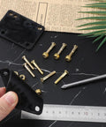 Hand holding black One Eighth Inch Rubber Skateboard Riser Pads With Mounting Screws And Nuts, on marble surface with ruler.
