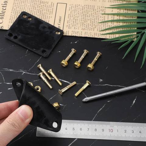 Hand holding black One Eighth Inch Rubber Skateboard Riser Pads With Mounting Screws And Nuts, on marble surface with ruler.