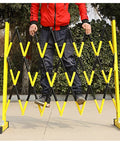Adjustable Telescopic Safety Barrier With Slick Glide Casters being set up by a person outdoors, demonstrating crowd control use.