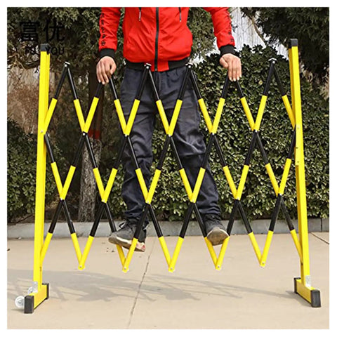 Adjustable Telescopic Safety Barrier With Slick Glide Casters being set up by a person outdoors, demonstrating crowd control use.