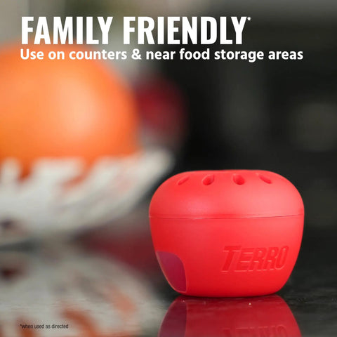 Indoor Fruit Fly Trap 4 Pack With 180 Day Food Based Lure, red apple-shaped trap on kitchen counter near fruit.