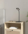 Black Bright Dimmable Eye Caring Desk Lamp With Three Color Modes on bedside table, featuring flexible gooseneck and touch control.