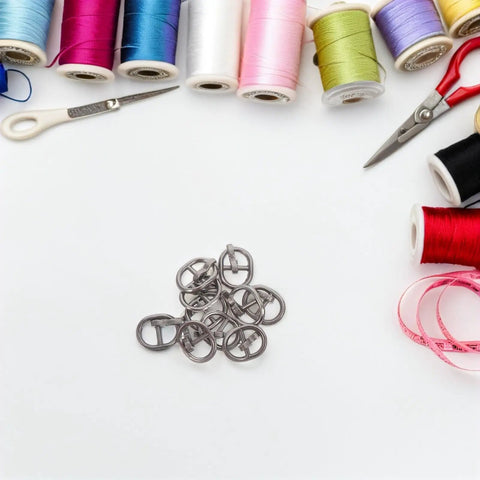 150 Pcs Miniature Alloy Buckles for Doll Clothes and DIY Projects, 5.5mm Single Prong Fasteners surrounded by sewing supplies