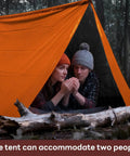 Two people inside Emergency Survival Tent Mylar Thermal Shelter for 1 or 2 people, orange color, in rainy forest setting.