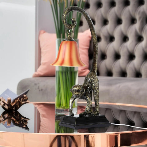 Modern Resin Bronze Monkey Table Lamp For Desk And Nightstand on a reflective coffee table