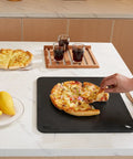 Person serving pizza on Heavy Duty Pizza Steel Plate For Oven And Grill 16 By 14.5 By Three Eighths Inch Carbon Steel Preseasoned