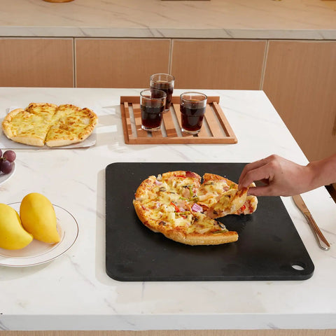 Person serving pizza on Heavy Duty Pizza Steel Plate For Oven And Grill 16 By 14.5 By Three Eighths Inch Carbon Steel Preseasoned