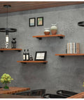 Tough As Nails Dual Pack Wall Mounted Floating Shelf Brackets In Industrial Black supporting wooden shelves with decor and plants.