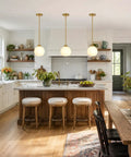 Two Pack Brushed Gold Globe Pendant Lights With Mid Century Modern Vibes And Smooth Opal Glass Shades Totally Adjustable Hanging Fixtures above kitchen island.