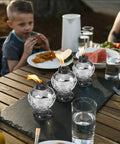 Four Pack Glass Table Torches With Citronella For Outdoor Patio And Garden on a dining table during a meal