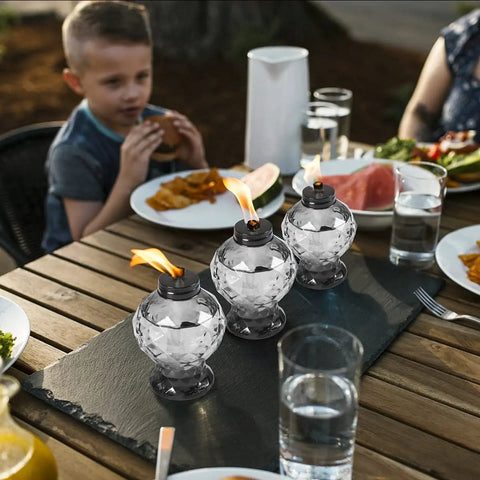 Four Pack Glass Table Torches With Citronella For Outdoor Patio And Garden on a dining table during a meal
