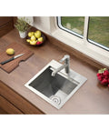 Stainless Steel Bar Sink 15 x 15 Inch Drop In Topmount Workstation Single Bowl Perfect For Kitchen Office Laundry Wet Bar RV Outdoor Yard Prep With Ultra Thick 3mm Rim And 16 Gauge Durability installed in kitchen counter with fruit nearby.