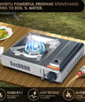10000 BTU Stainless Steel Camp Stove With Wind Blocker Portable Gas Stove For Camping Tailgating And Outdoor Cooking In A Durable Carry Case Fuel Not Included, lit burner on a picnic table with food.