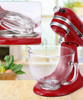 KitchenAid tilt-head stand mixer with glass bowl, detailed view of attachment mechanism in a kitchen setting.