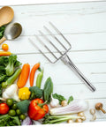 Heavy Duty Workhorse Garden Fork For Digging And Transplanting Beans Stainless Steel Hand Fork With vegetables on a wooden background