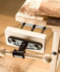 Heavy Duty Carpentry Bench Vise With Manual Threaded Screw For Tightening Workpieces During DIY Cutting Or Sanding And Assembly Projects In Your Workshop on a wood tabletop.