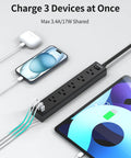 Ultra Thin Flat Plug Power Strip With 6 Foot Cord, 5 Outlets And 3 USB Ports Including 2 USB C, in use charging devices.
