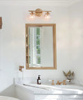 Two Light Gold Vanity Lighting Fixture With Globe Seeded Glass Shades For Bathroom Slick Modern Dark Gold Finish above mirror