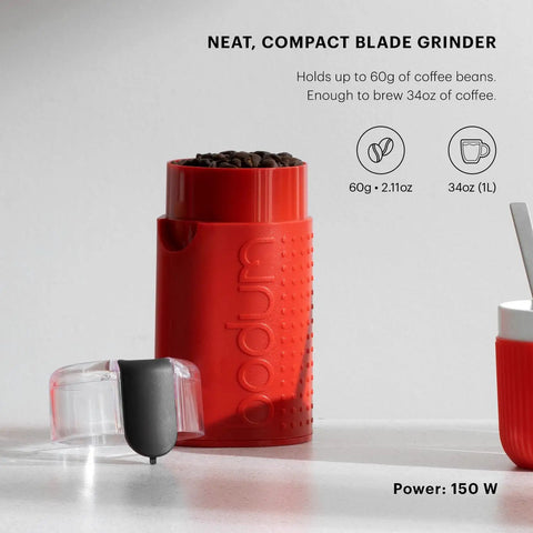 Snag This Sleek Electric Blade Coffee Grinder Featuring Durable Stainless Steel Blades Easy Push Button Control Crystal Clear Lid And Secure Cord Storage For Premium Daily Grinding In Bold Red with coffee beans.