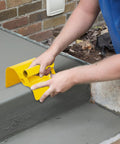 Person using a concrete curb trowel edger for edging and curbing projects, pro grade stainless steel hand tool with ergonomic design.