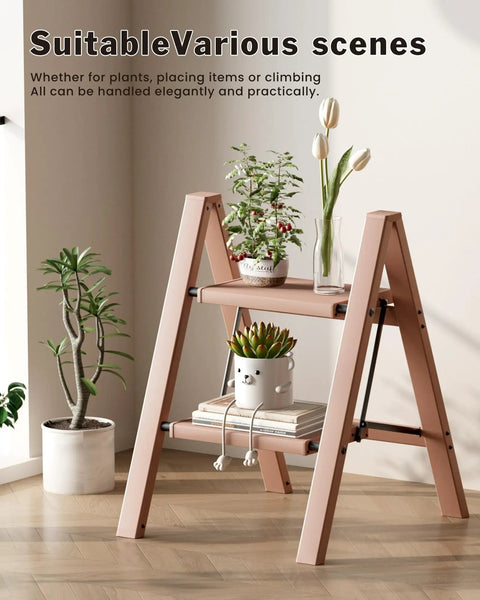 Compact 2 Step Stool Foldable Aluminum Ladder For Home And Garage, Ultra Lightweight Portable Step Ladder, Folds To A Slim 1.9 Inch Profile, Opens In A Snap, No Assembly, 6.2 Lb Net Weight, Easy Storage And Grab And Go Transport. Pink 2-step aluminum ladder with plants indoors.