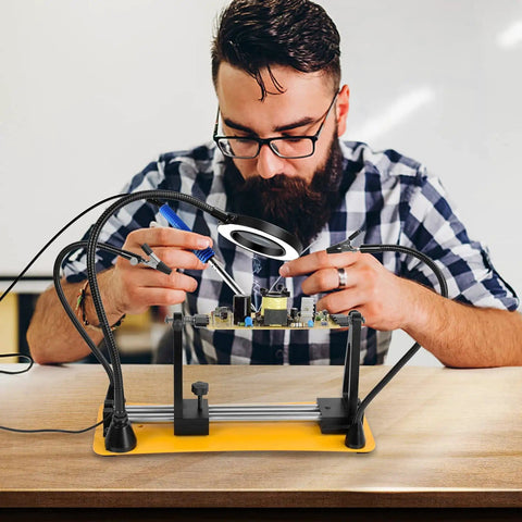 Man using Helping Hands Magnetic Soldering Station With Pro Grade 360 Degree Flip Two Flexible Gooseneck Arms And 3X Magnifying Glasses