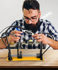 Man using Soldering Circuit Board Holder With 360 Degree Adjustable Flip And 5X Magnifying Gooseneck Arms for stable repairs.