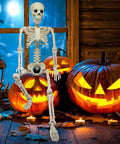 36 Inch Full Body Skeleton Prop With Movable Joints Realistic Plastic Bones next to jack-o-lanterns in Halloween display