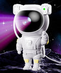 Astronaut Galaxy Star Projector Nebula Night Light With Timer And Remote For Kids And Adults on a rocky surface with starry background.