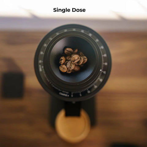Solid Single Dose Coffee Grinder Featuring 63Mm Red Titanium Conical Burrs And Plasma Ionizer To Crush Beans Sick Flat And Eliminate Static Drama For Flawless Pulls In Sleek Black Housing with coffee beans inside.