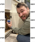 Man installing Real Time Water Flow Meter For Irrigation And Garden Hose GPM Usage Monitor in a kitchen cabinet
