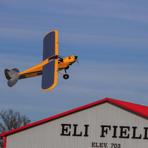 Carbon Cub 15cc ARF Ready To Fly RC Plane With Laser Cut All Wood Construction soaring above a hangar