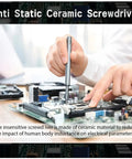 Person using anti-static ceramic screwdriver on a computer motherboard to prevent electrical interference during assembly.