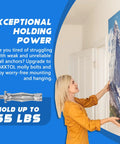 Woman using Heavy-Duty Molly Bolts For Drywall And Plaster Walls Kit to hang a framed mountain picture in a home setting