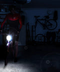 Cyclist using USB Rechargeable Bike Front Light With 200 Lumen LED Output For Day And Night Visibility in dark room