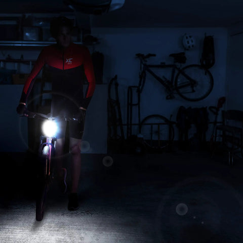 Cyclist using USB Rechargeable Bike Front Light With 200 Lumen LED Output For Day And Night Visibility in dark room