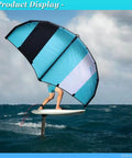 Rider using Go Anywhere Packable Inflatable Wing with Hydrofoil for wing foiling on ocean waves, blue and black wing visible