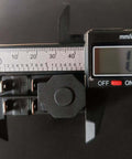 Close-up of a 4-pin electromagnetic pushbutton switch with caliper measurement, part of the Electromagnetic Pushbutton Switch Set, 4 Pin, 1/2 HP, Double Pole, 16A At 120V, Compatible With 120V And 220V Systems, Heavy Duty Starter Buttons For Garden Tools And Power Machinery, 2 Pack.