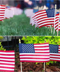 Six Pack 4x6 Inch Small American Flags On Wooden Sticks Handheld USA Flags With Kid Safe Spear Top For Outdoor Use on grass